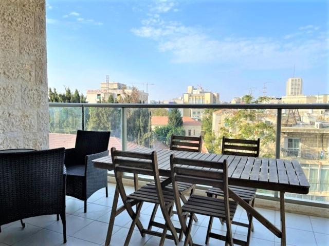 耶路撒冷Best location and family-friendly的观景阳台配有一张木桌和椅子。
