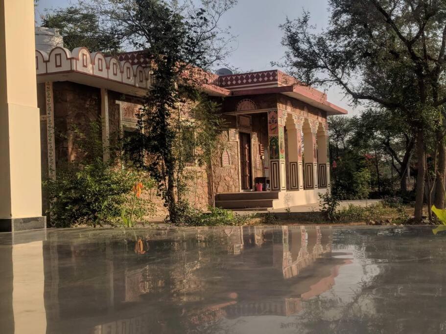 斋浦尔Prabhu Niwas Jaipur 45 km on Delhi Road的倒影在水中的一个建筑