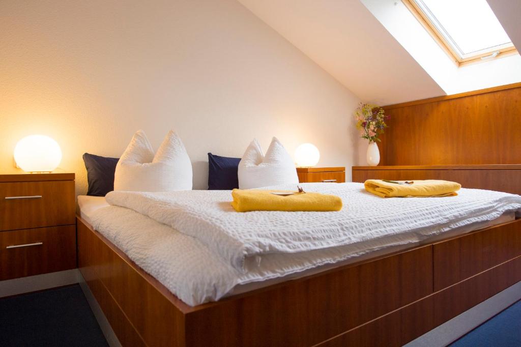 柏林Pension Freiraum Guesthouse Berlin的一间卧室配有一张带两张黄色毛巾的床
