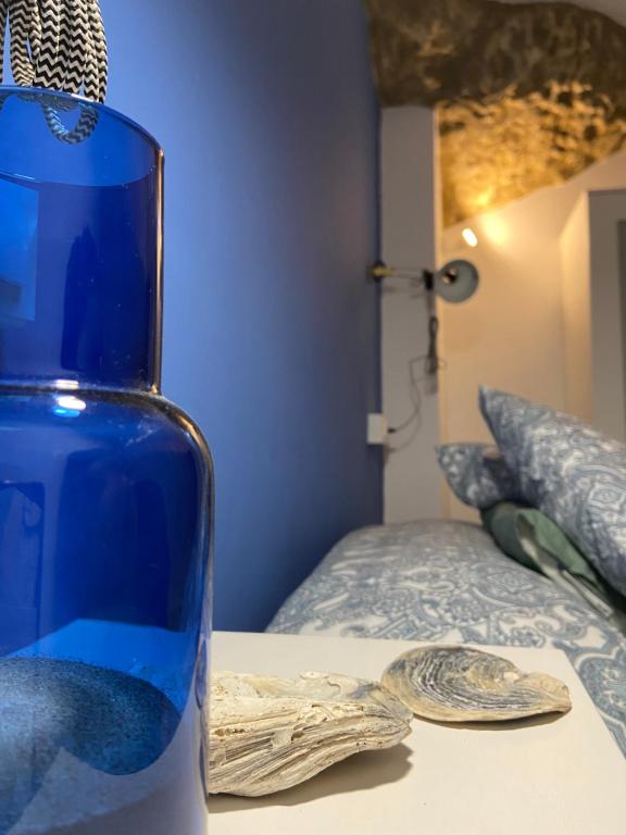 塞特尼尔Casa del Mar a la Sierra的一张睡床旁边的桌子上有一个蓝色的花瓶