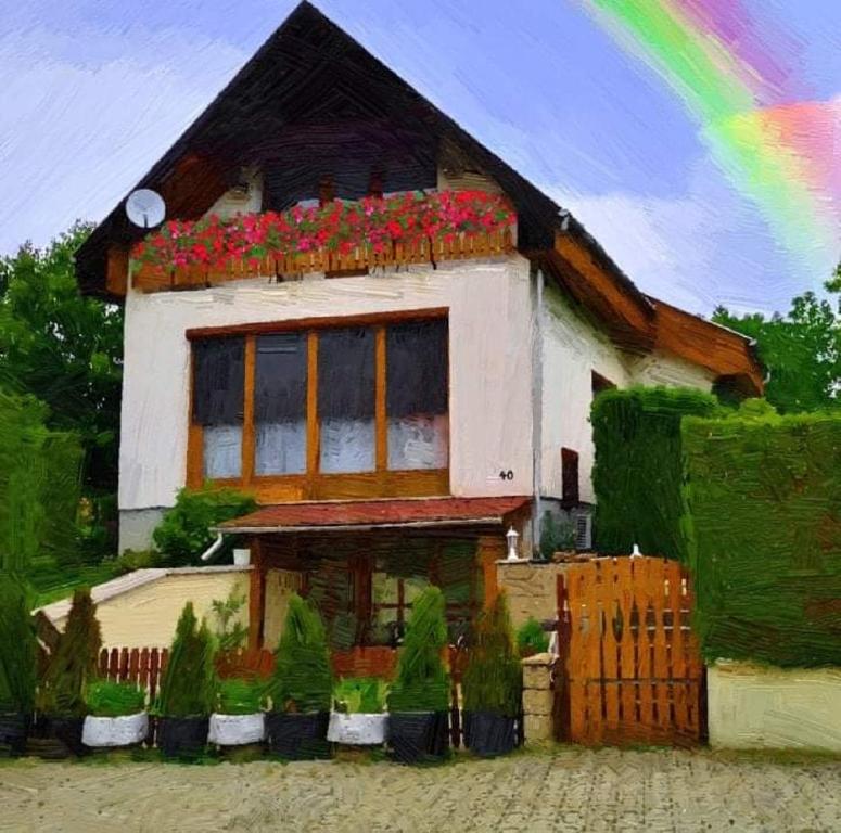 VértestolnaSzivárvány Vendégház的上面有花的房子的画