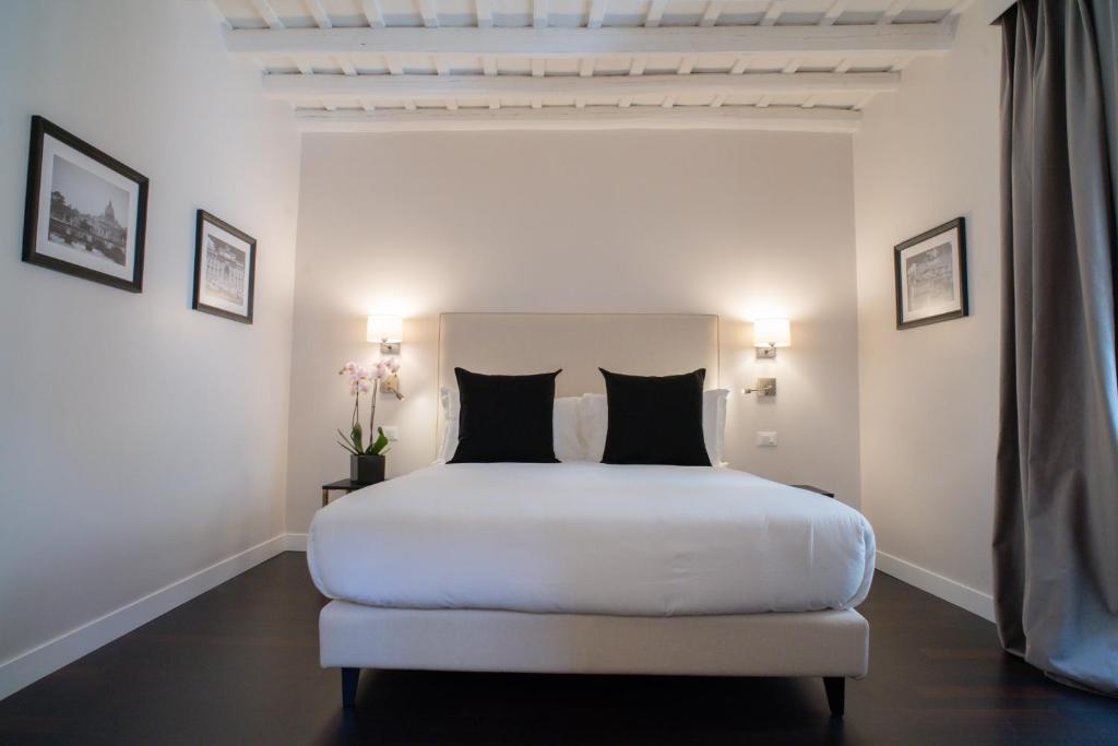 罗马冰砾大厅酒店的白色卧室配有白色的床和黑色枕头