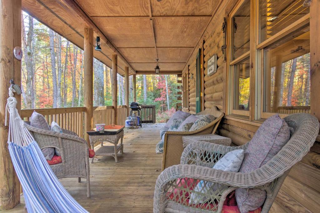 Cedar MountainCedar Mountain Log Cabin 4 Mi DuPont State Forest的小木屋的门廊配有椅子和桌子