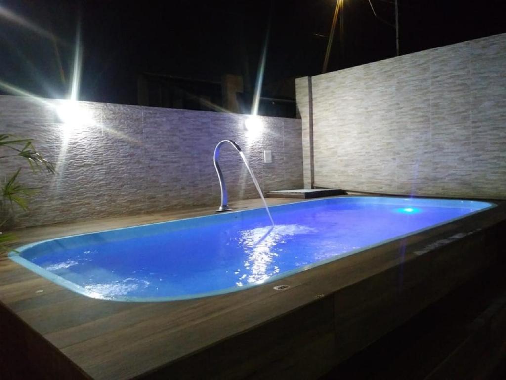 卡拉瓜塔图巴casa letic. praia Indaia的浴室内设有带水龙头的大型蓝色浴缸