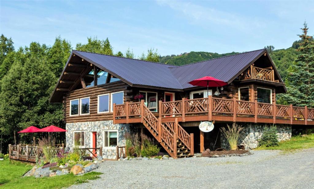 荷马 唐棣住宿加早餐旅馆的带阳台和红色遮阳伞的大型小木屋