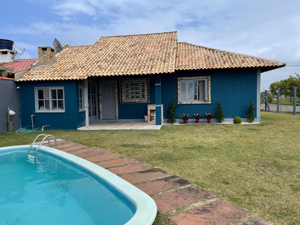 因贝Casa Família Sander的蓝色的房子,前面设有一个游泳池