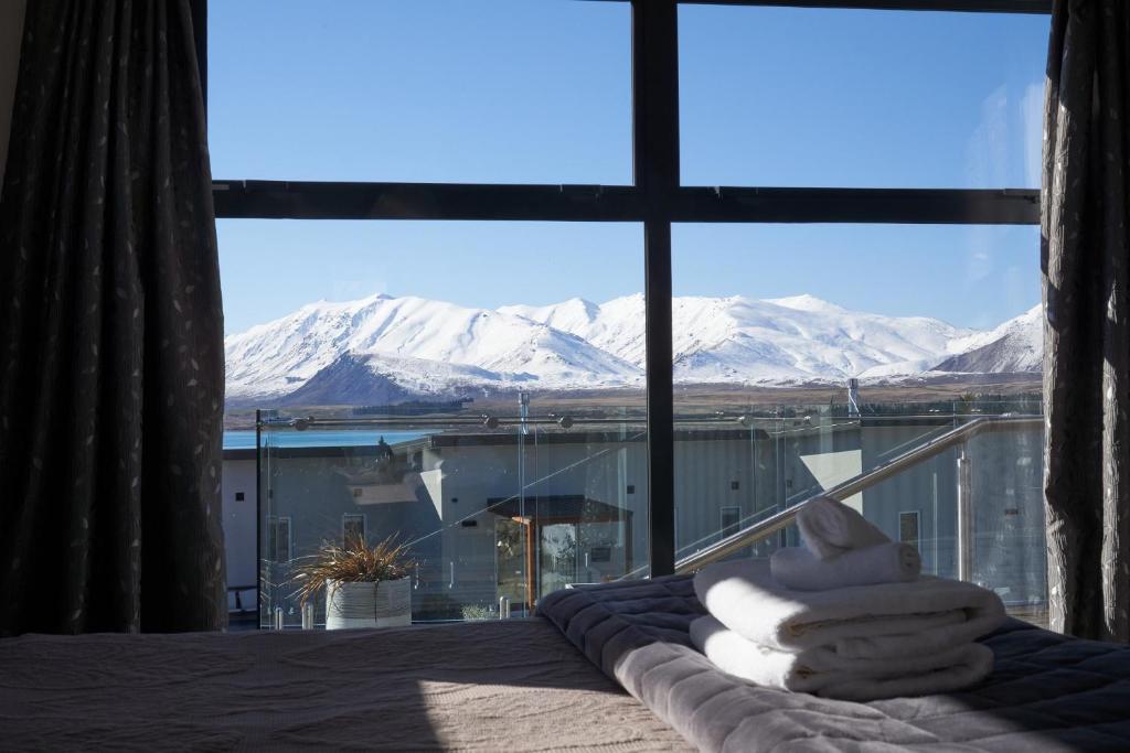 特卡波湖Alpine View Apartment 3 - Tekapo的卧室设有窗户,享有白雪 ⁇ 的山景