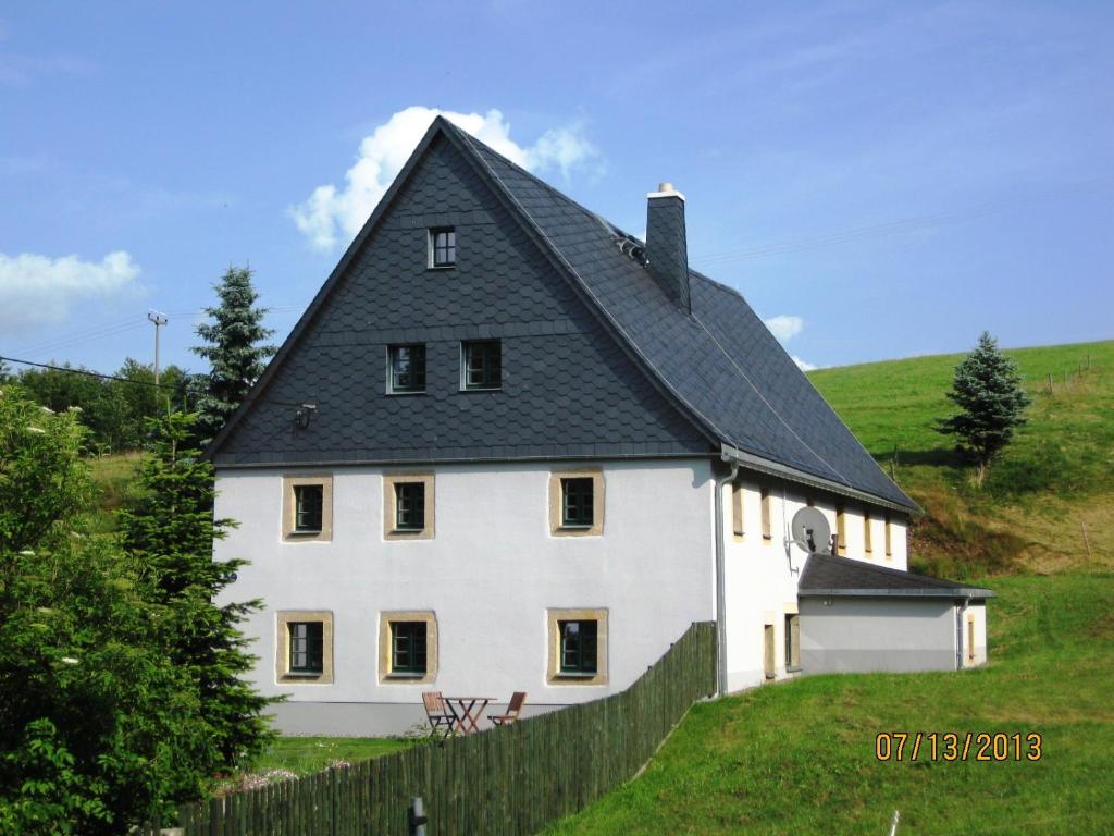 GlashütteFerienhof Herm的黑色屋顶的大型白色房屋