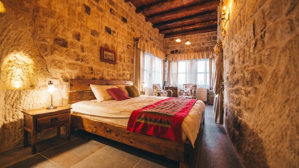内夫谢希尔Cappadocia Old Houses的卧室配有一张石墙床