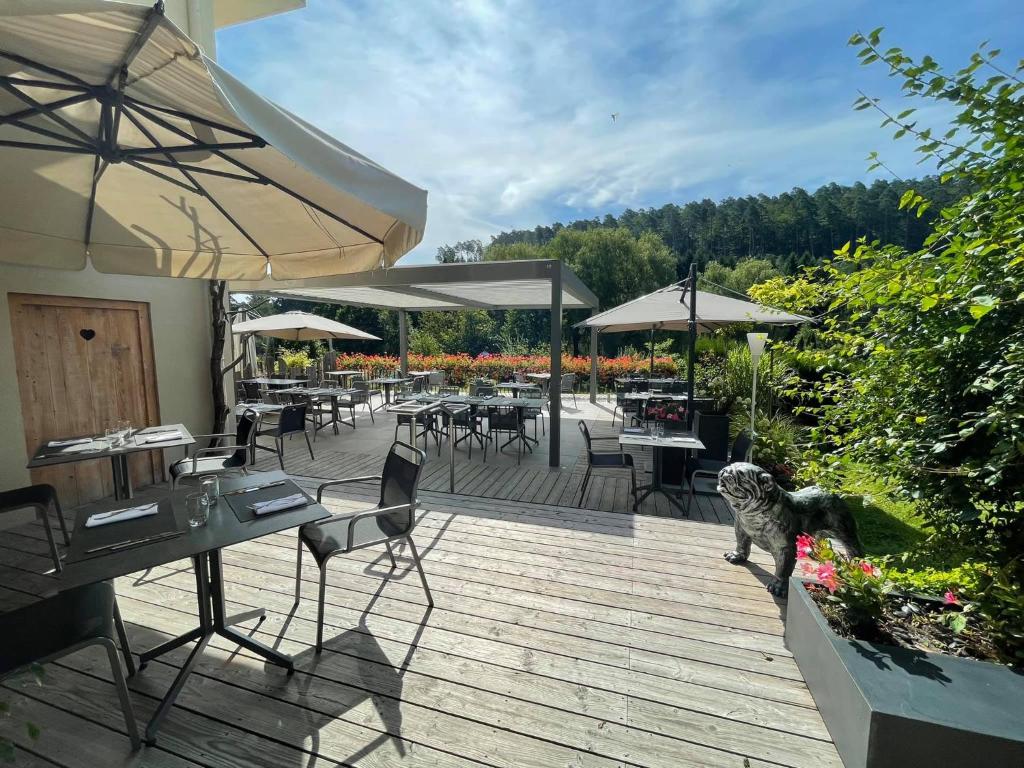 ReipertswillerHôtel Restaurant La Couronne by K的木甲板配有桌椅和遮阳伞