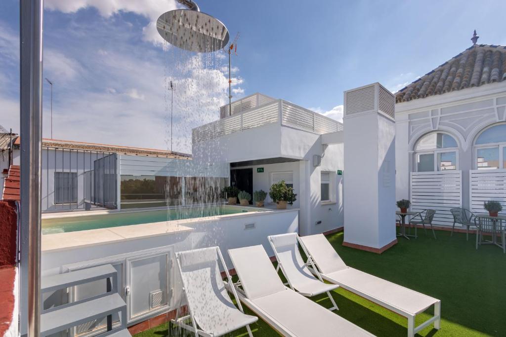 塞维利亚LS9- La Palmera Luxury by Valcambre的庭院设有白色椅子和喷泉