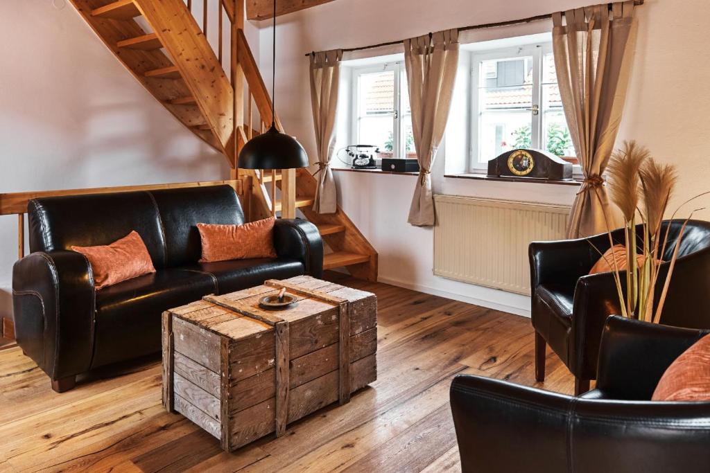 BöttingenFerienhaus Lilace的客厅配有皮革家具和桌子