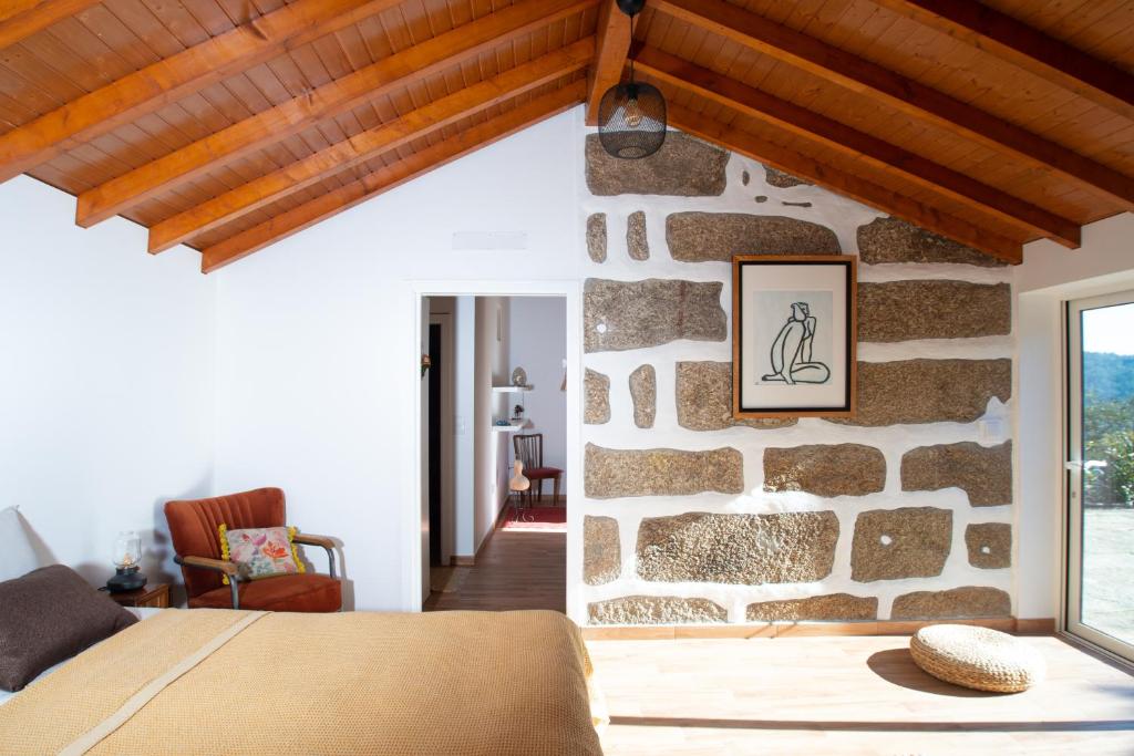 派瓦堡Family Room - Quinta do Mirante的一间卧室设有石墙,配有一张床