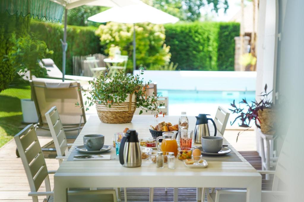 安德诺莱斯贝恩Chambres d'hôtes Villa Surcouf的庭院里一张带食物的白色桌子