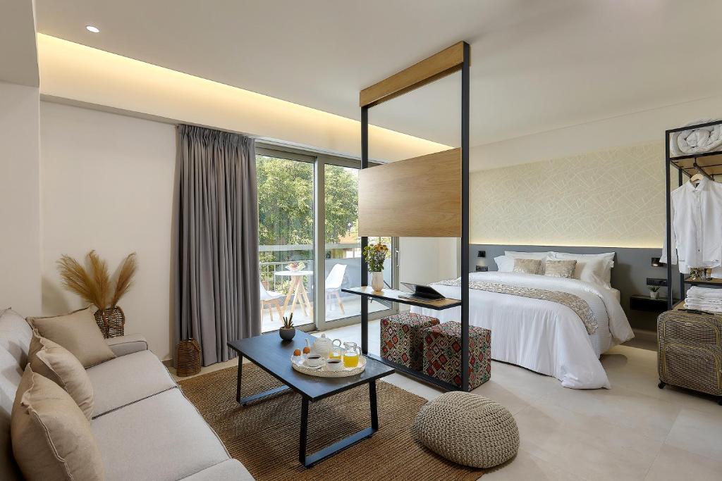 海若克利欧Stay 365 Heraklion Apart Hotel的一间卧室配有一张床、一张沙发和一张桌子