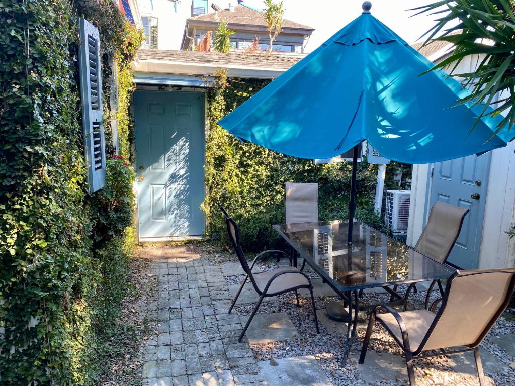 新奥尔良Antonine Apartment Upper Garden District的一个带桌子和遮阳伞的庭院