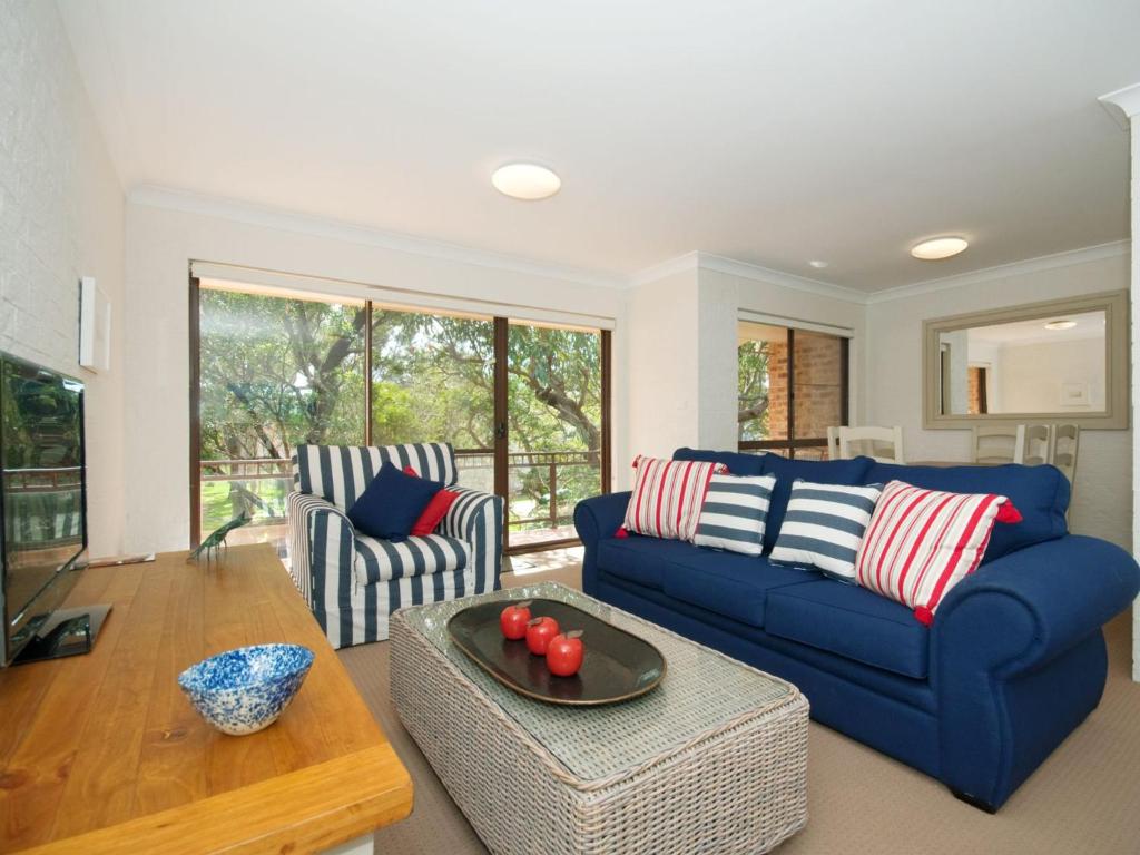 尼尔森湾Bay Parklands Unit 35 2 Gowrie Avenue的客厅配有蓝色的沙发和桌子