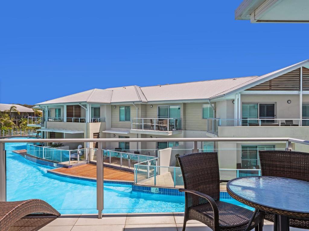 萨拉曼德湾Pacific Blue Adjoining Apartments 244A and 244B 265 Sandy Point Rd的一个带桌椅的阳台和一个游泳池