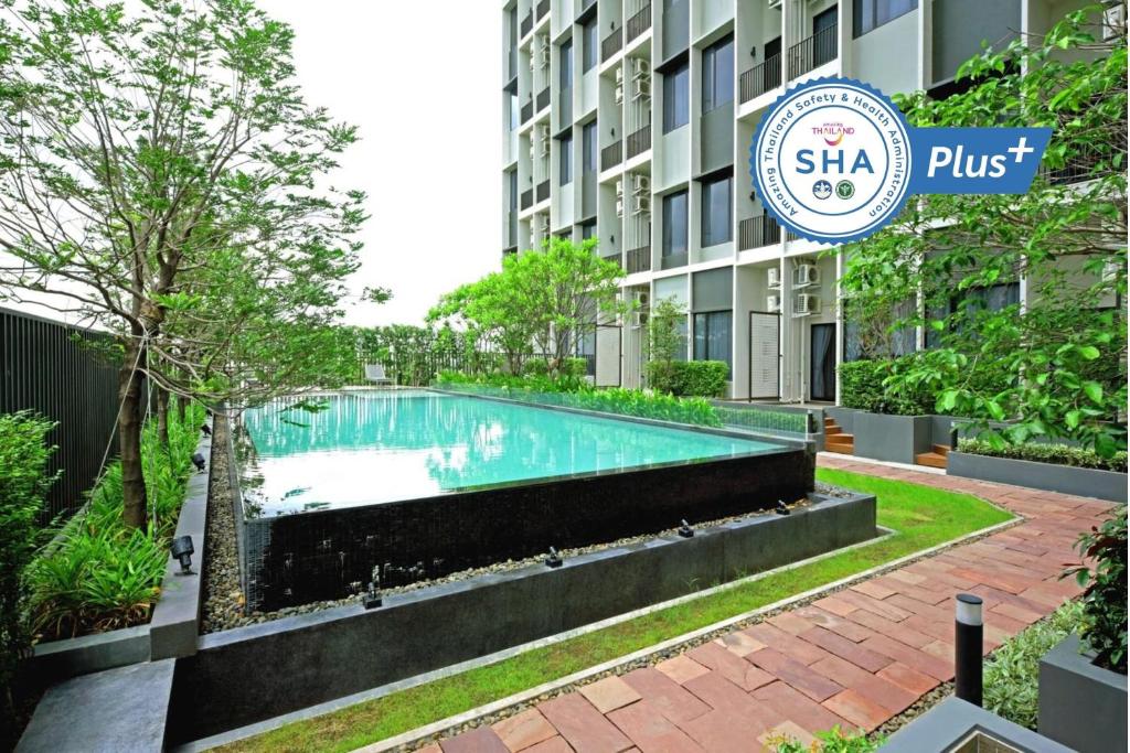 曼谷Q Box Hotel Bangkok Blossom SHA Plus的大楼前的游泳池