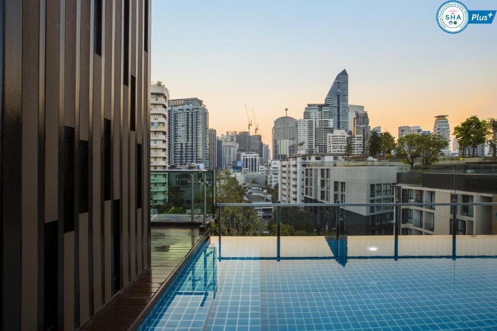曼谷阿德菲49酒店的一座城市天际线建筑屋顶上的游泳池
