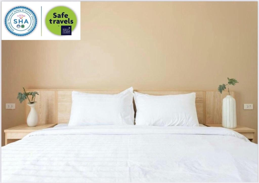 华富里O2 Hotel Lopburi的卧室配有白色的床单和枕头