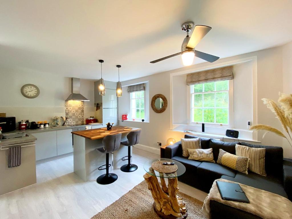 托基Meadfoot Bay Apartment at Hesketh Crescent的厨房以及带沙发和桌子的客厅。