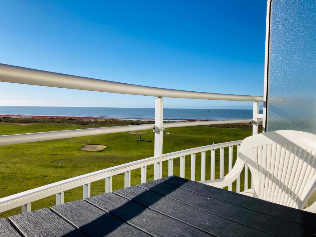 圣让-德蒙Studio du golf, standing, piscine, forêt et océan的阳台配有白色椅子和海洋