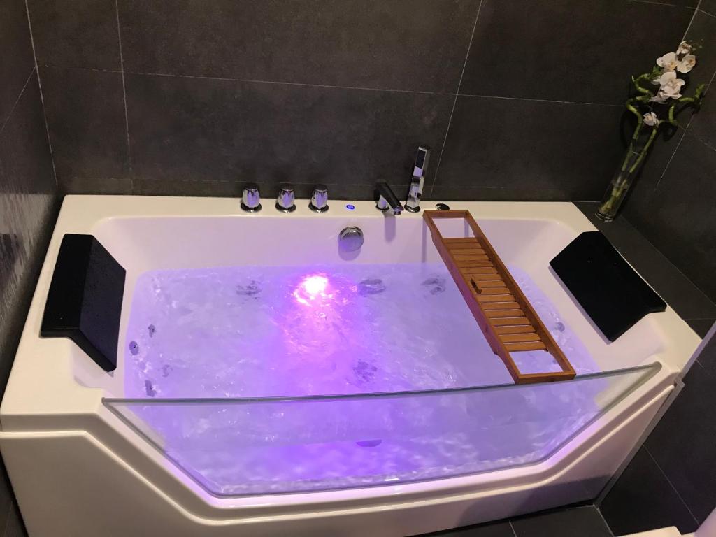 马贝拉Suite Vitbanus的白色浴缸,配有紫色