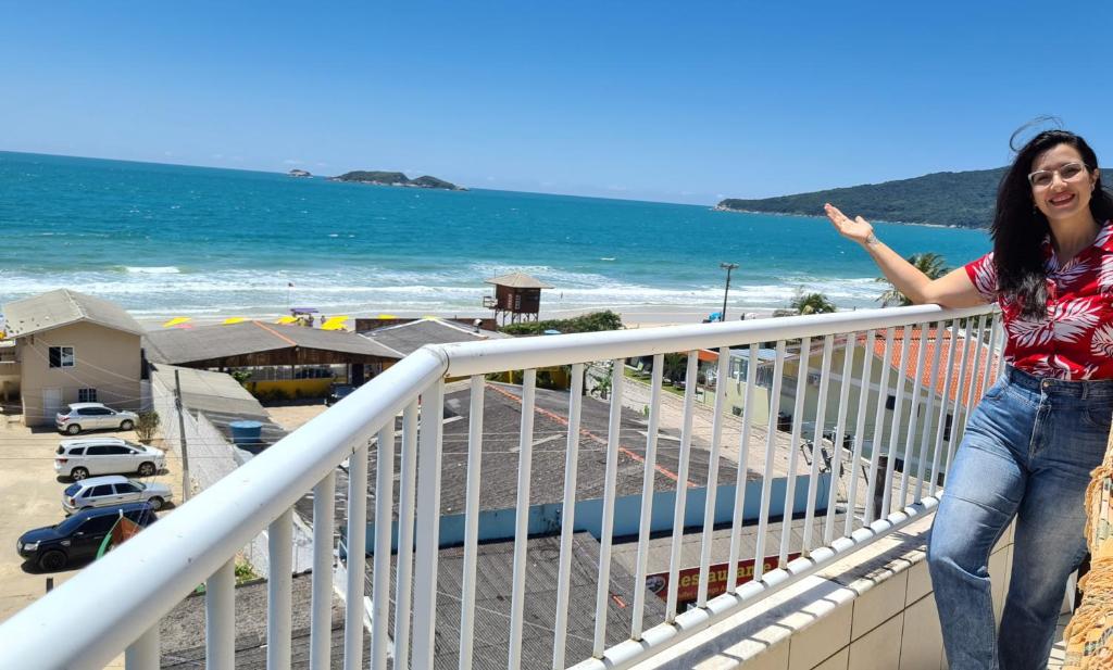 弗洛里亚诺波利斯Praia Pousada Tatuíra的站在海滩旁阳台的女人