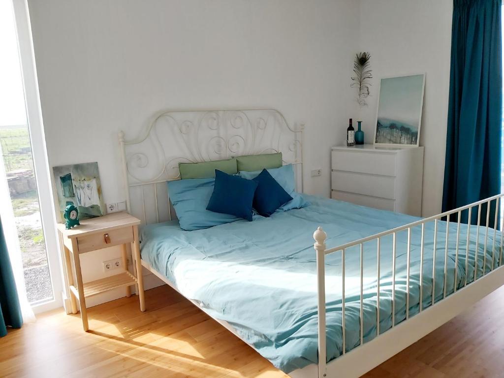 阿尔梅勒Luxury Suites Oosterwold的一间卧室配有一张带蓝色枕头的床