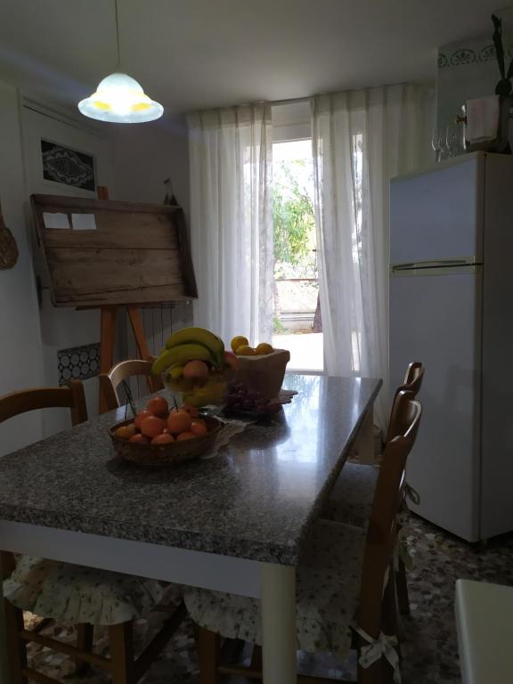 滨海波利尼亚诺Casa dei sospiri的一张厨房桌子,上面放着一碗水果