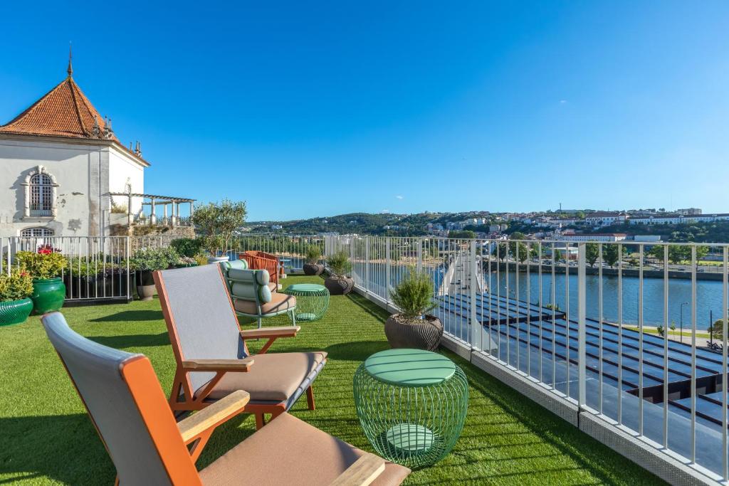 科英布拉Hästens Sleep Experience FLH Hotels Coimbra的阳台配有椅子,享有水景
