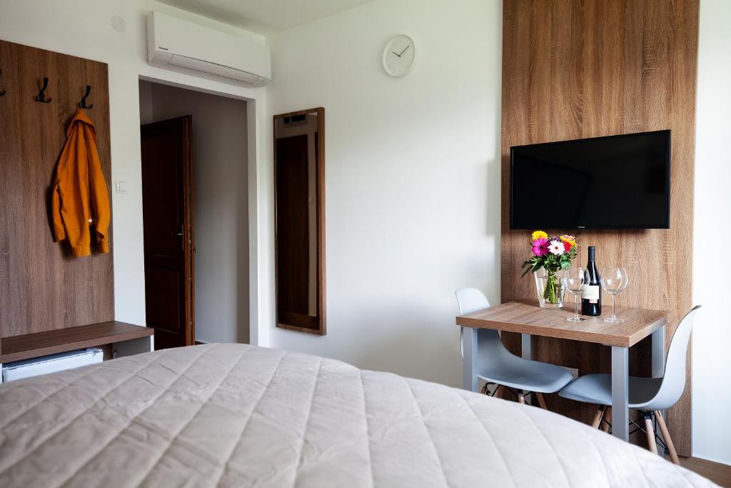 迈泽克韦什德HVT Comfort Apartments的一间卧室配有一张床和一张书桌及电视