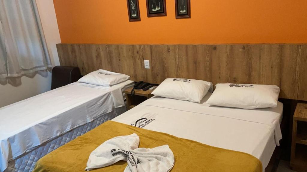 纳塔尔潘塔内格拉小海湾酒店的一间设有两张床铺和毛巾的房间