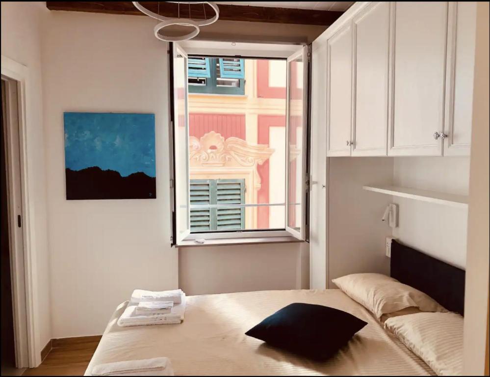 卡莫利Camogli Eden - Luxury apartment的卧室在窗户前配有一张床