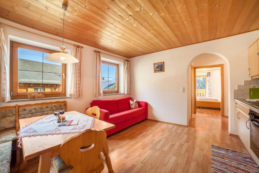 摩梭Egarthof Ferienwohnung Alpenrose的客厅配有红色的沙发和桌子