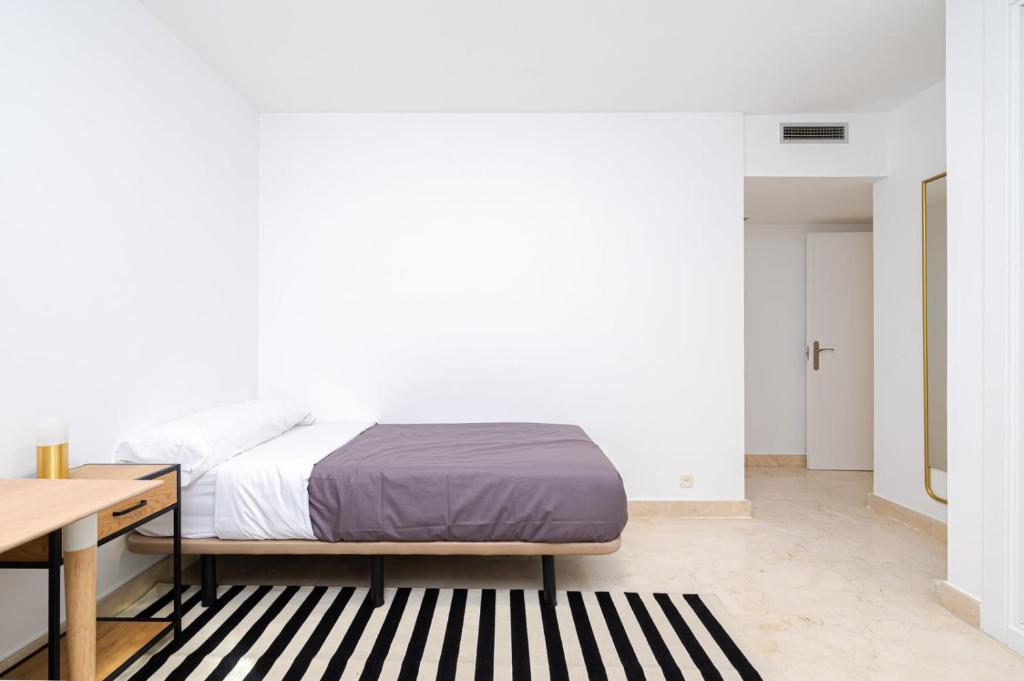 马德里Los Castaños Design Apartments in Conde Orgaz Area的一间卧室配有一张床、一张书桌和一张书桌