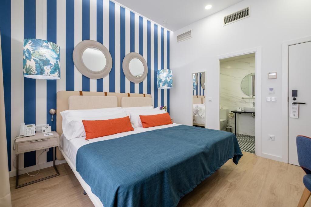 马拉加Soho Boutique Urban的一间卧室配有一张蓝色和白色条纹的床