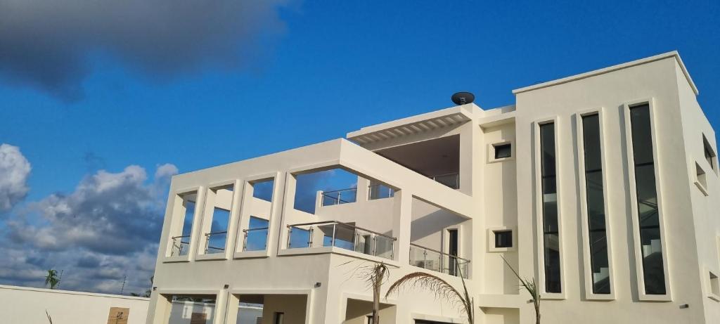 BonouaVilla Bolati, avec piscine, jacuzzi, jardin et vue的白色的建筑,有蓝色的天空