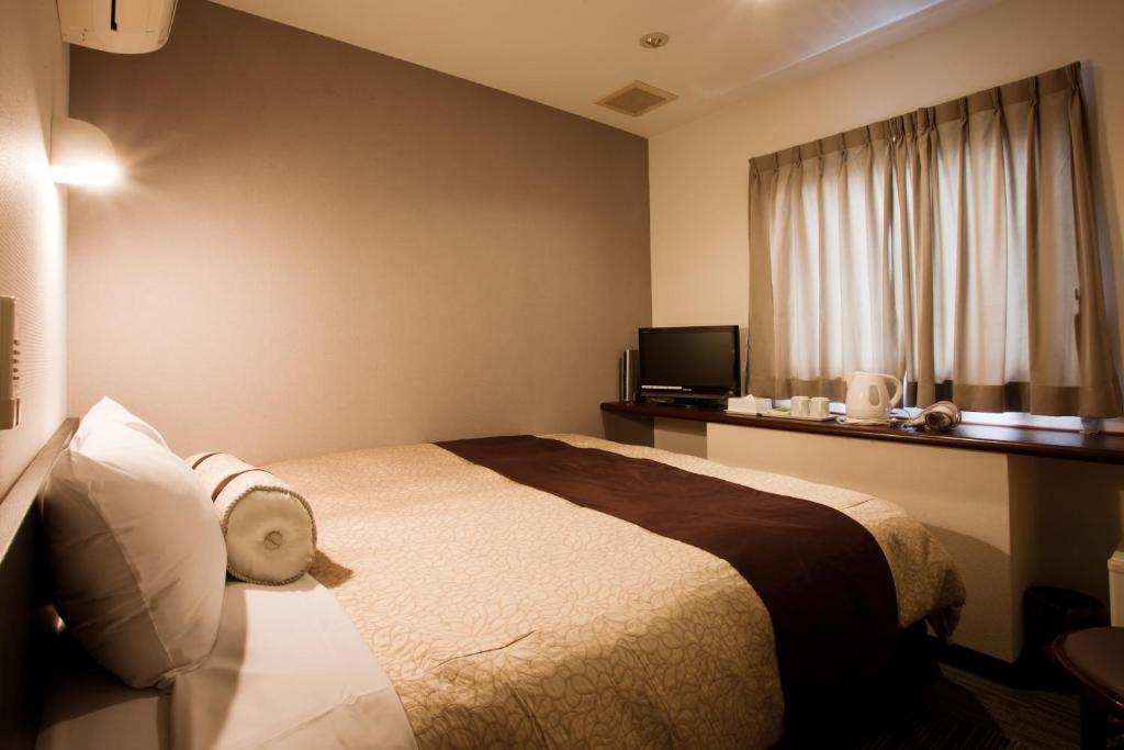 挂川市挂川站酒店的酒店客房设有床和窗户。