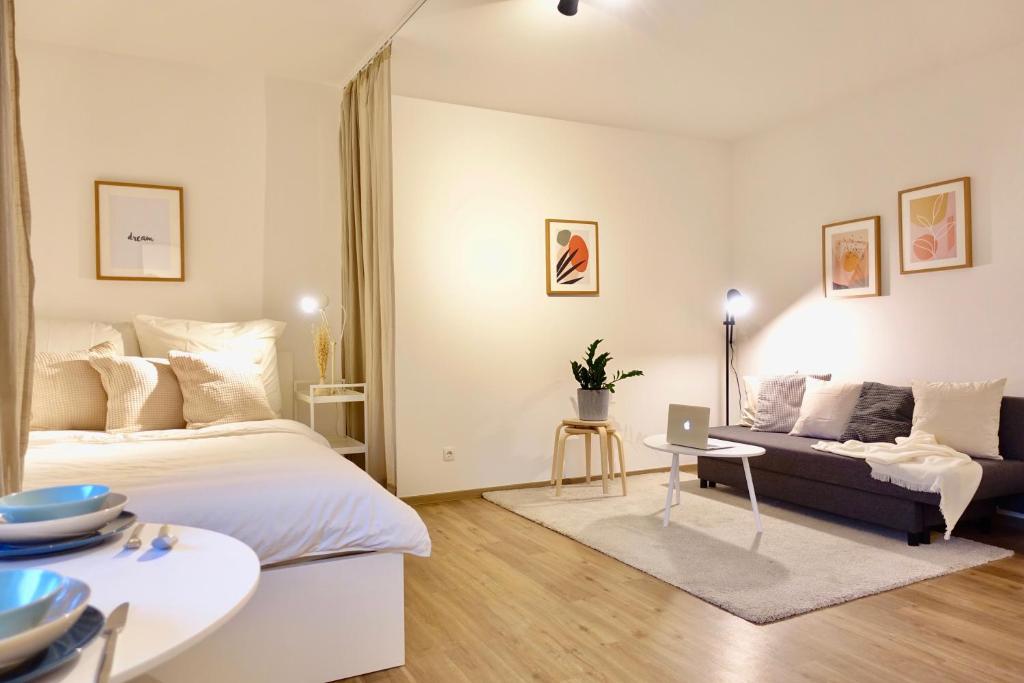 科布伦茨NEU - gemütliches und modernes Apartment mit Stellplatz的一间卧室配有一张床、一张沙发和一张桌子