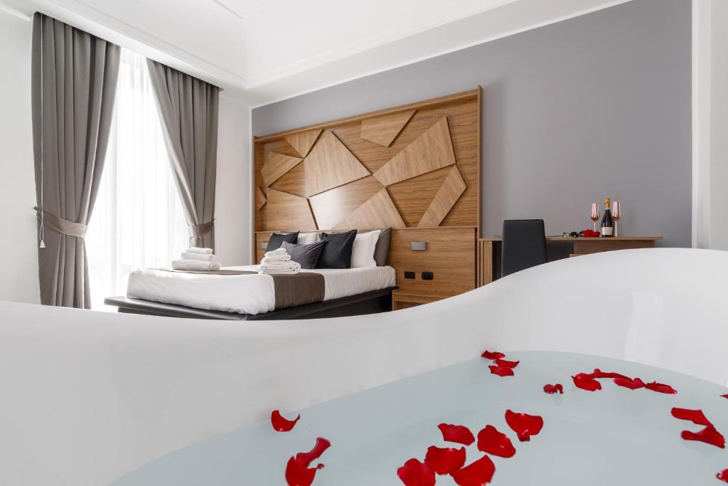 那不勒斯Sant'Angelo Suites的一间卧室,床上铺有红色玫瑰花瓣