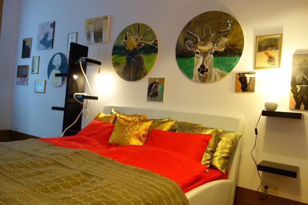 克拉科夫Sebastian Gold的一间卧室配有一张带红色枕头的床,墙上挂有钟。