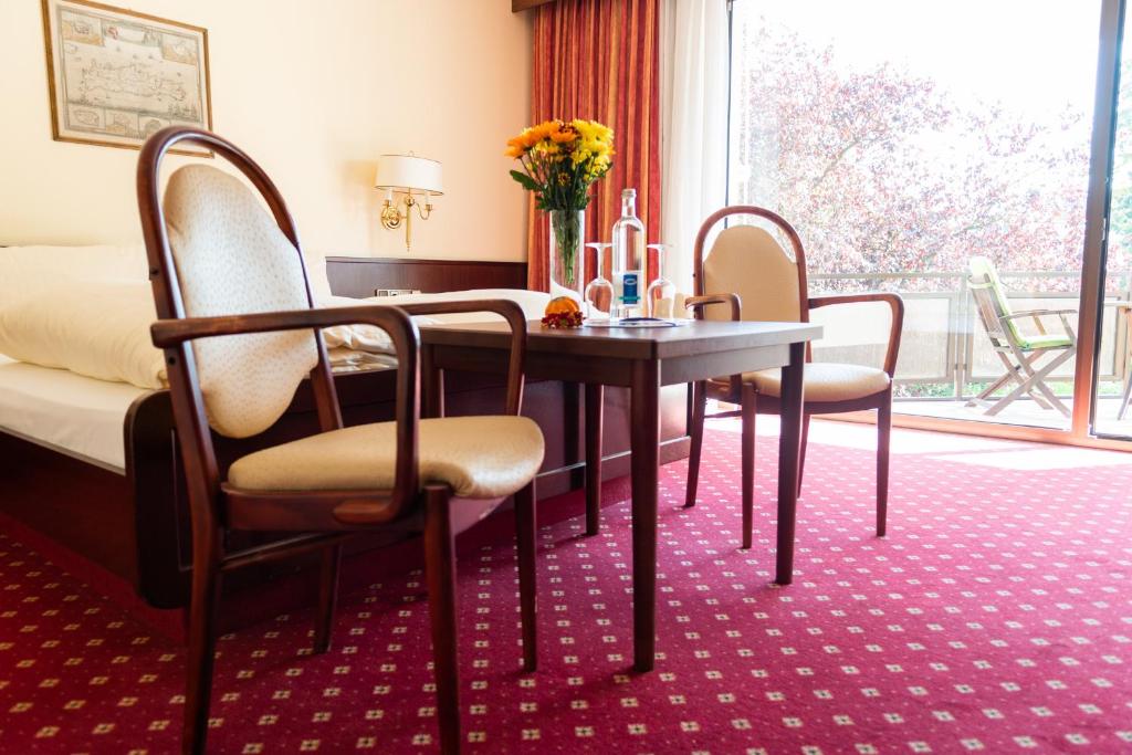 杜塞尔多夫豪斯艾美珠酒店的配有桌椅和床的房间
