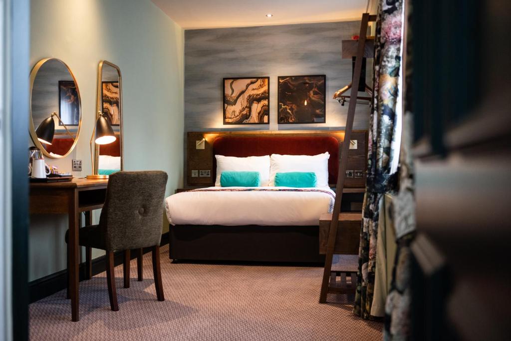 哈罗盖特The Pine Marten by Innkeeper's Collection的酒店客房带一张床铺、一张书桌和一间卧室
