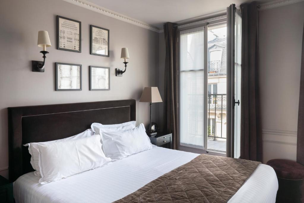巴黎圣路易皮嘉尔酒店的卧室配有带白色枕头的床和窗户。