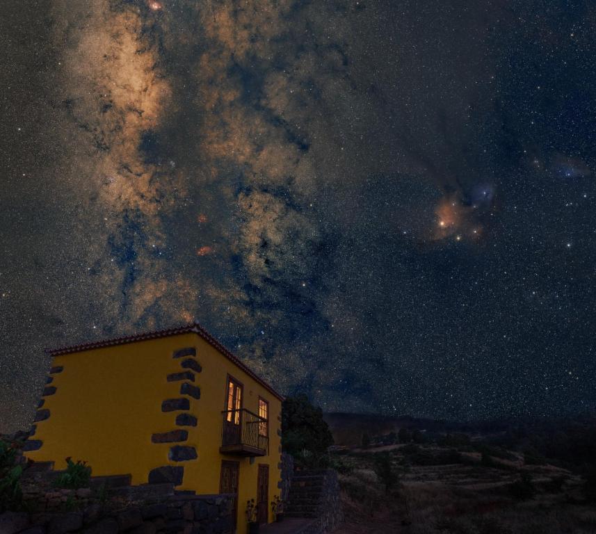HoyagrandeCasa Rural de Abuelo - Con zona habilitada para observación astronómica的夜空下黄色的建筑