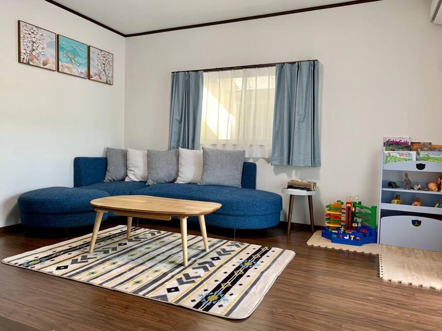 奈良Nara Family HOUSE的客厅配有蓝色的沙发和桌子