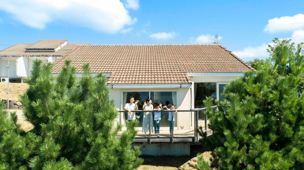 土庄町YURURI private cottage的一群人站在房子的阳台上