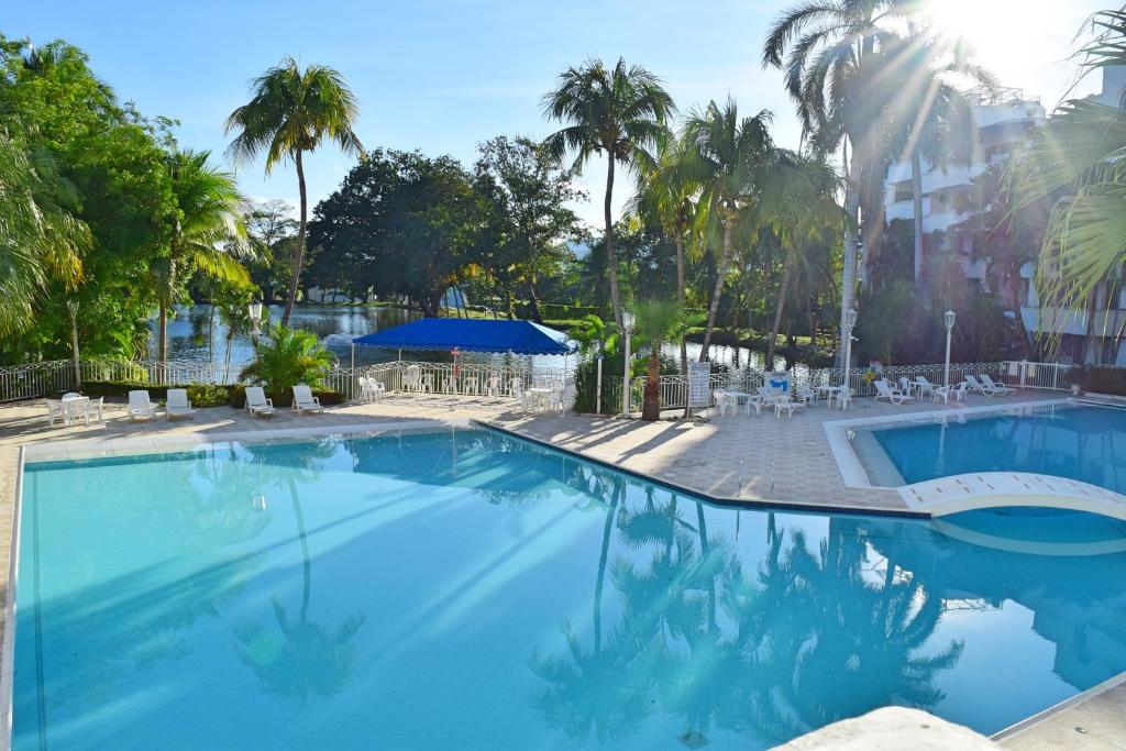 吉拉尔多特Cristales, Condominio Lagos del Peñon的一座棕榈树环绕的大型游泳池